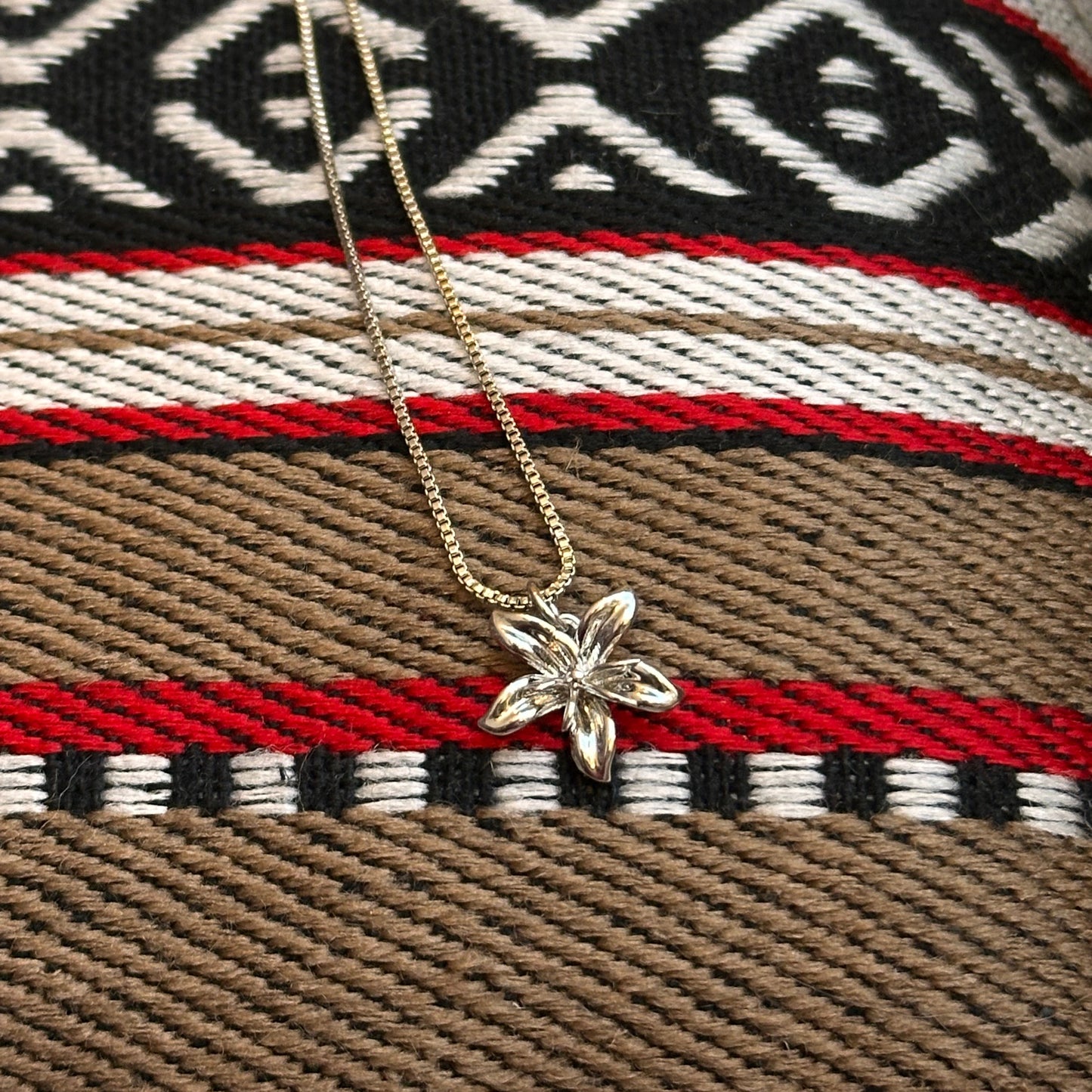 Necklace with a butterfly pendant on a patterned fabric background