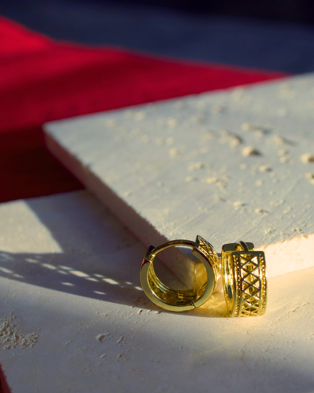Gold hoop earring Moroccan earrings called Marrakesh Infront of a ivory stone
